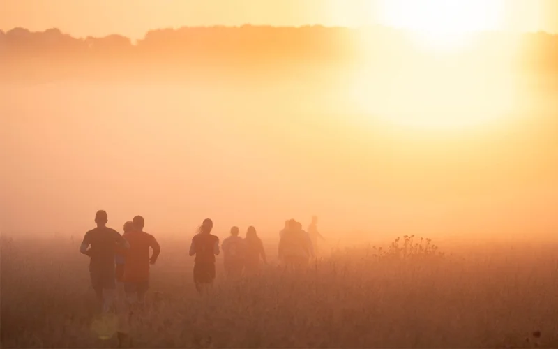 A group of people running in the early morning of the summer solstice in Wiltshire, England.