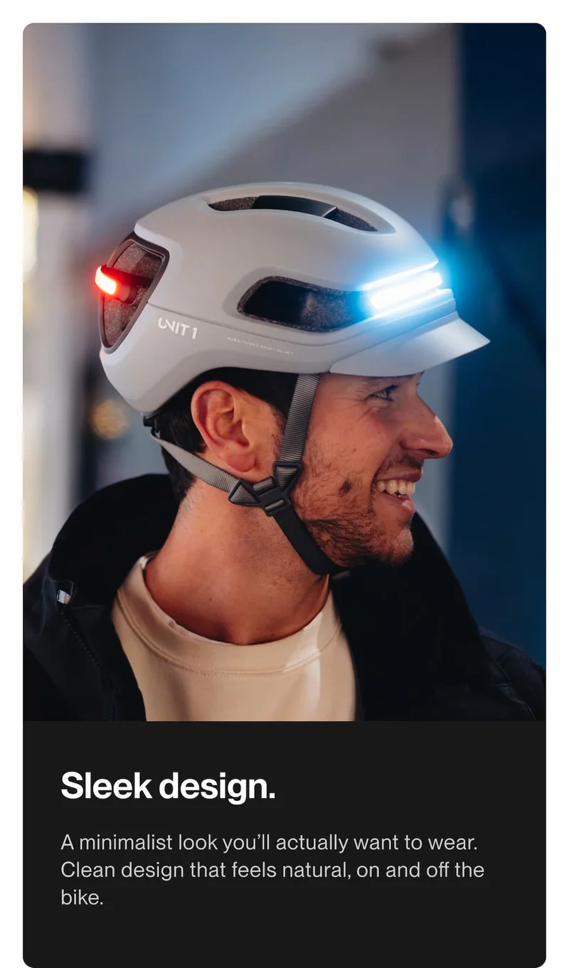 Man wearing a UNIT 1 smart bike helmet with illuminated front and rear lights, showcasing a sleek, minimalist design for everyday riding