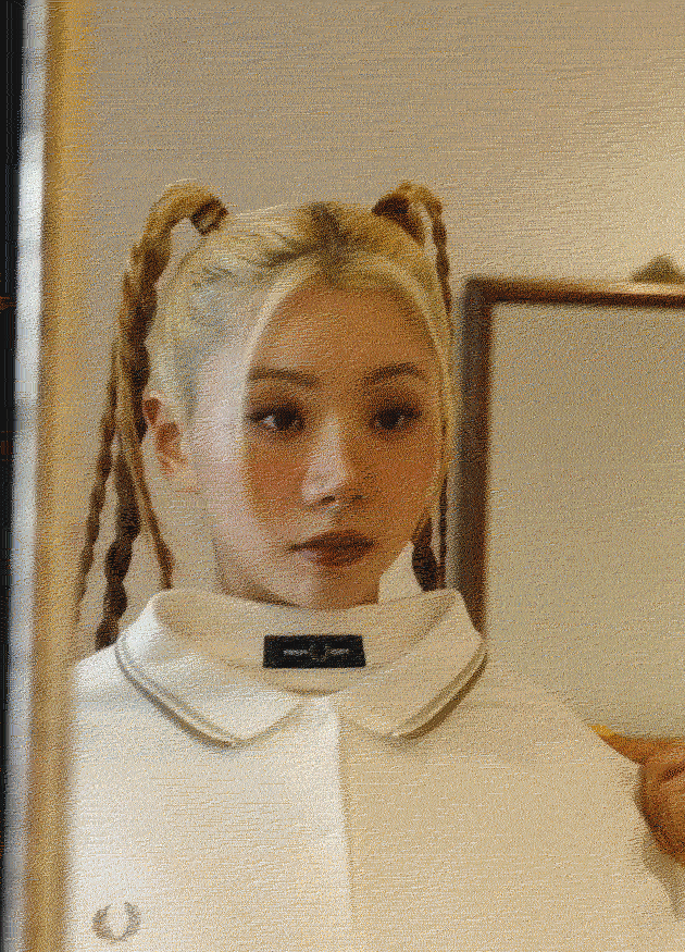 GIF of Asian Woman trying on a white Fred Perry polo shirt
