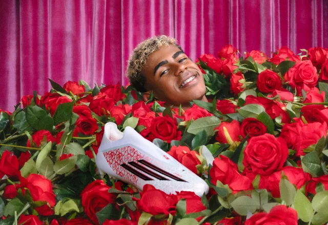 Lamine Yamal lies in a sea of roses, smiling with just his head showing next to his signature adidas F50 cleats.