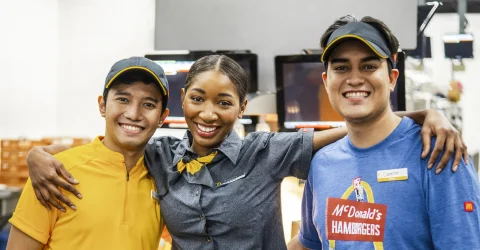 McDonald's Crew members stand behind the counter. They're a tight-knit team, ready to serve.