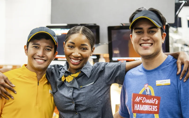 McDonald's Crew members stand behind the counter. They're a tight-knit team, ready to serve.