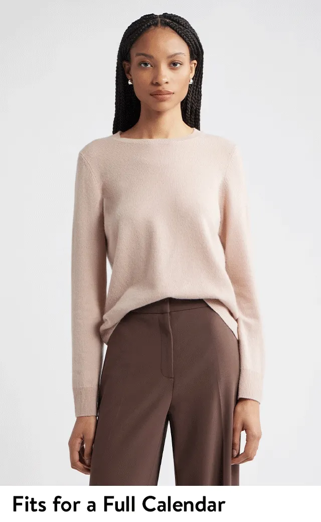 A woman wearing a cashmere sweater and trousers; a man wearing a merino wool V-neck sweater, button-up shirt and pants.