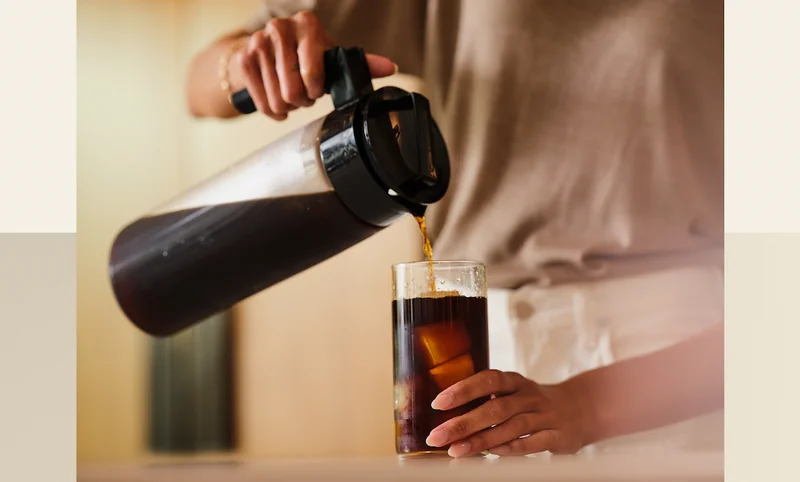 Fresh cold brew being poured from a Takeya Cold Brew Coffee Maker into an iced glass.
