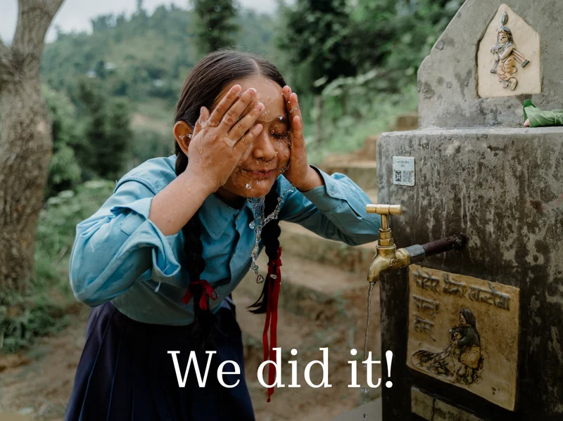 A photo of a Nepalese girl washing her face at a school water source. Text overlay: We did it! (Thanks to you)