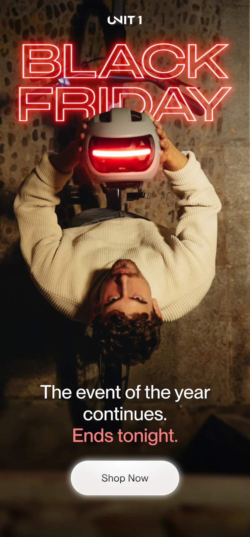 Cyclist holding a UNIT 1 smart helmet with illuminated rear light under a Black Friday neon header, with messaging highlighting that the event ends tonight.
