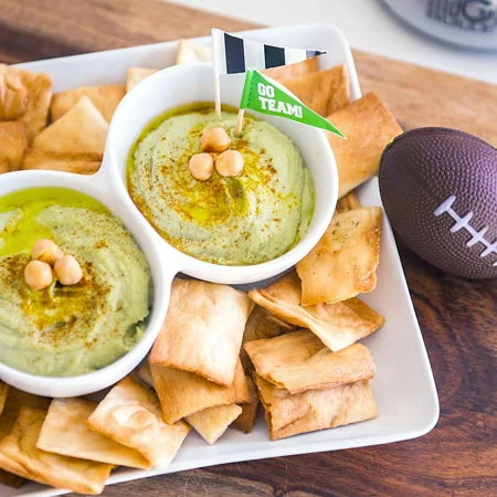 Avocado hummus served with crackers, promoted as a nourish by nutribullet recipe for game day.