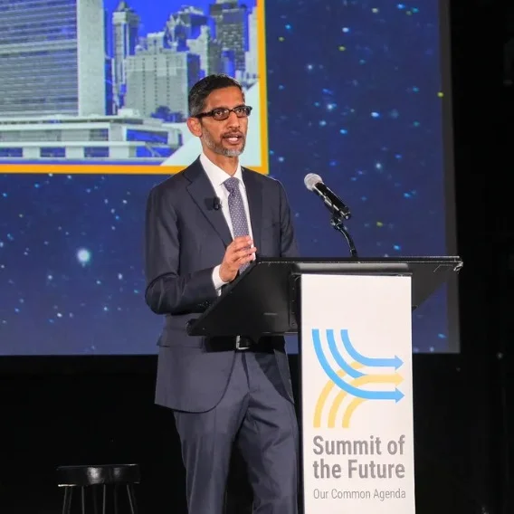 a picture of Google CEO Sundar Pichai speaking at a lectern on a stage