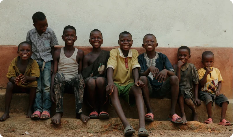 Children sitting against a wall in Sierra Leone