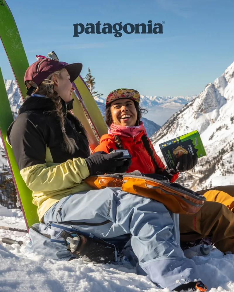 Patagonia. Two backcountry skiers eating food in the snow.