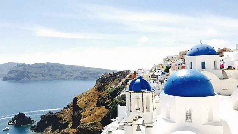 Image description: Scenic view of blue-domed churches in Santorini, Greece.