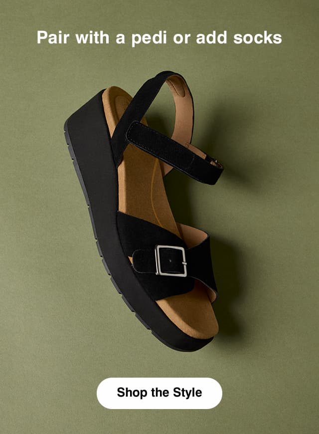 The Baminda sandal in Black suede styled with an ankle strap, buckle vamp strap, and perfect-height wedge. The email says Pair with a pedi or add socks. Shop the Style.