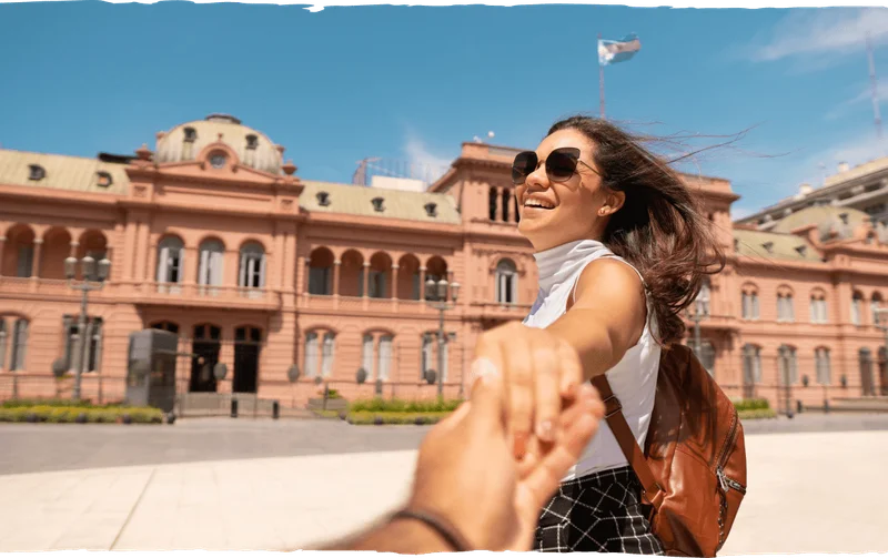 Image Description: A female traveler smiling outside Casa Rosada while holding the photographer’s hand