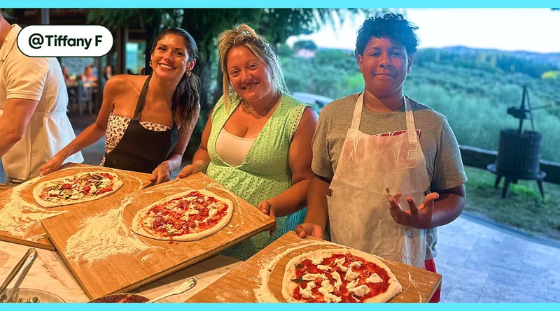 Image description: Three people posing with handmade pizzas on wooden paddles.