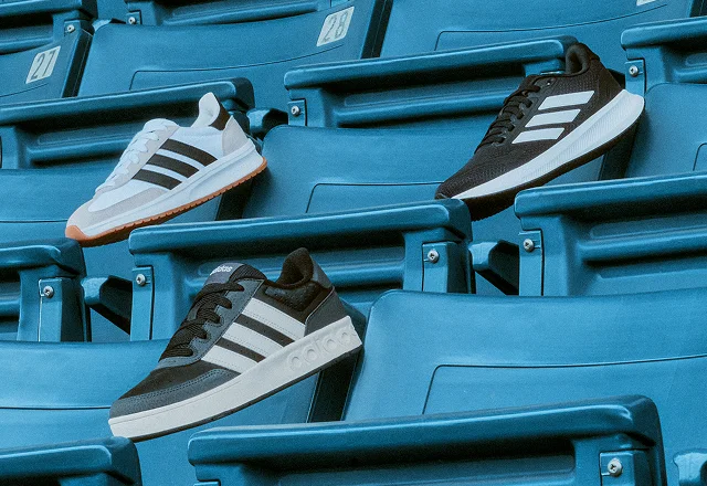 Three adidas shoes on stadium seats