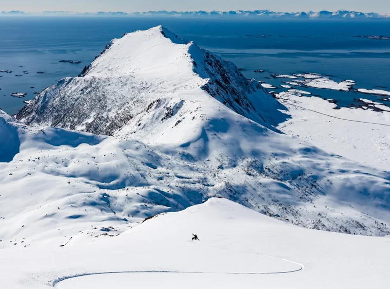 A snowboarder makes wide turns down the mountain.
