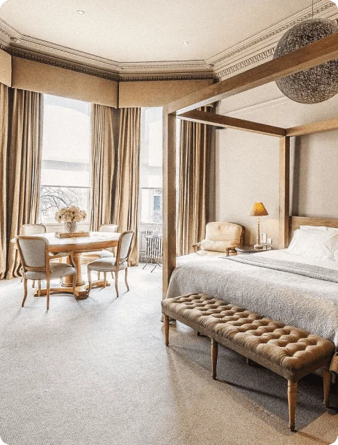 Image Description: A stylish hotel suite featuring a canopy bed, a chaise lounge, and a communal table in The Murrayfield Hotel, Edinburgh