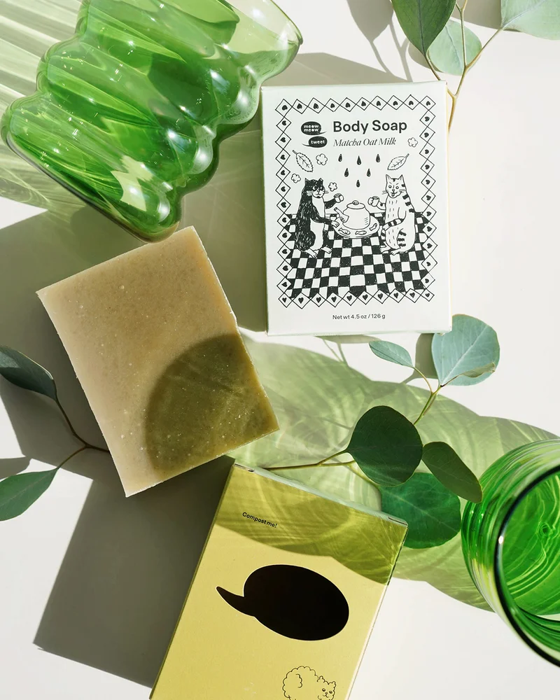 A haphazard flat lay of the matcha bar and its box and glasses and leaves