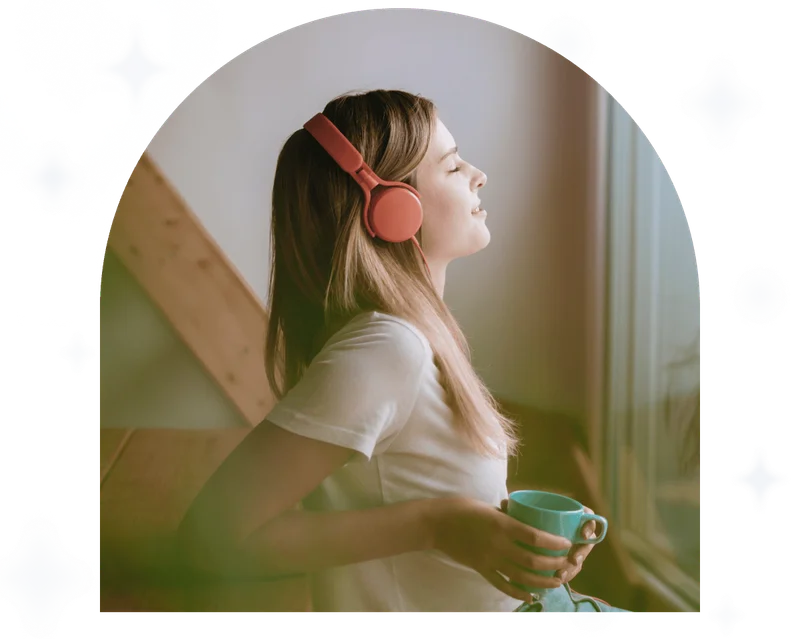 Young woman relaxing at home with a cup of tea, listening to meditation