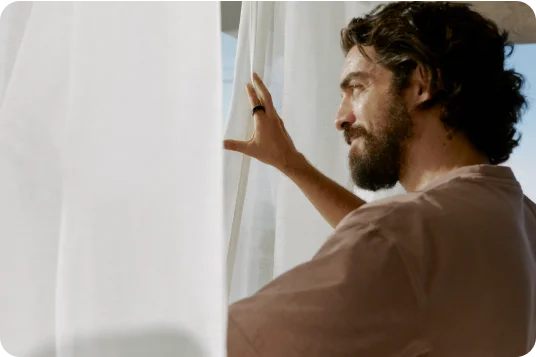 Person wearing Oura Ring looking out a window