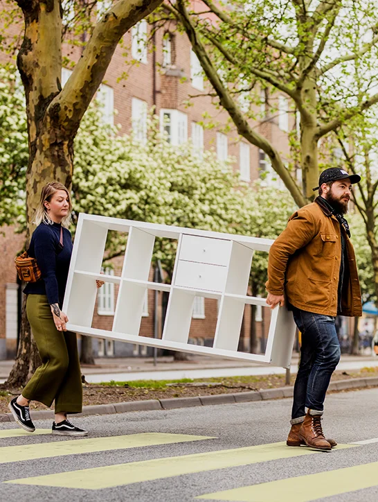 2 People moving a piece of IKEA furniture outside