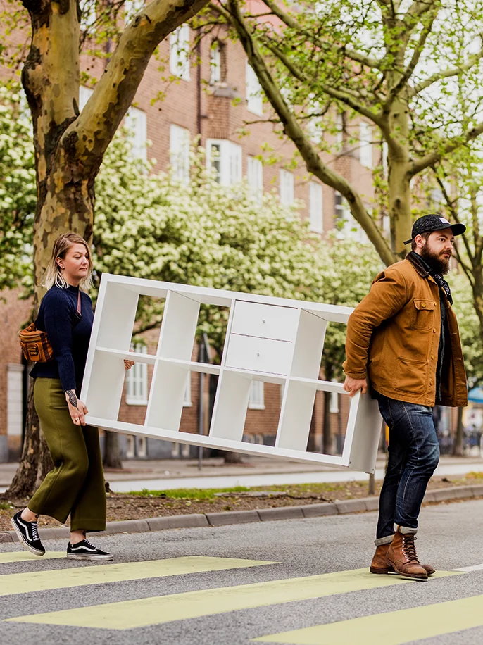 2 People moving a piece of IKEA furniture outside