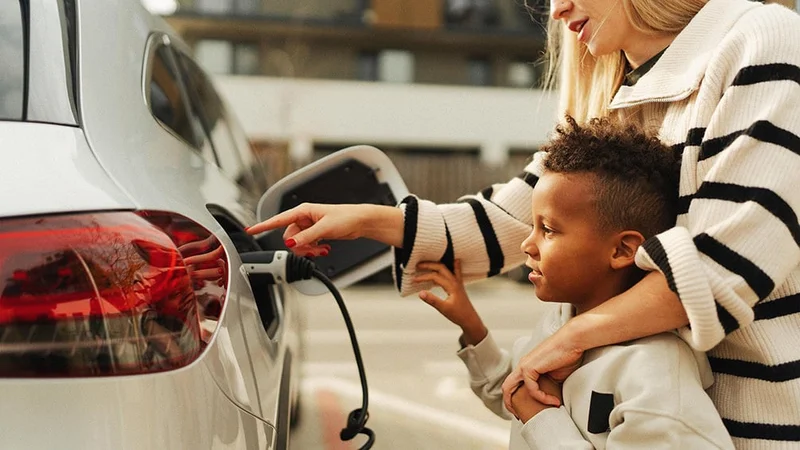 Image description: Mother and son with car at EV charging station