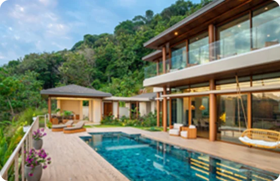 Modern villa with glass walls, wooden accents, and a pool surrounded by lush tropical greenery.