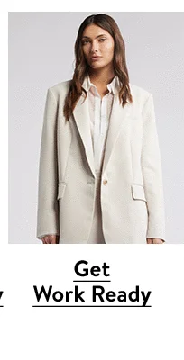 A woman wearing a white blazer, white shirt and white skirt.