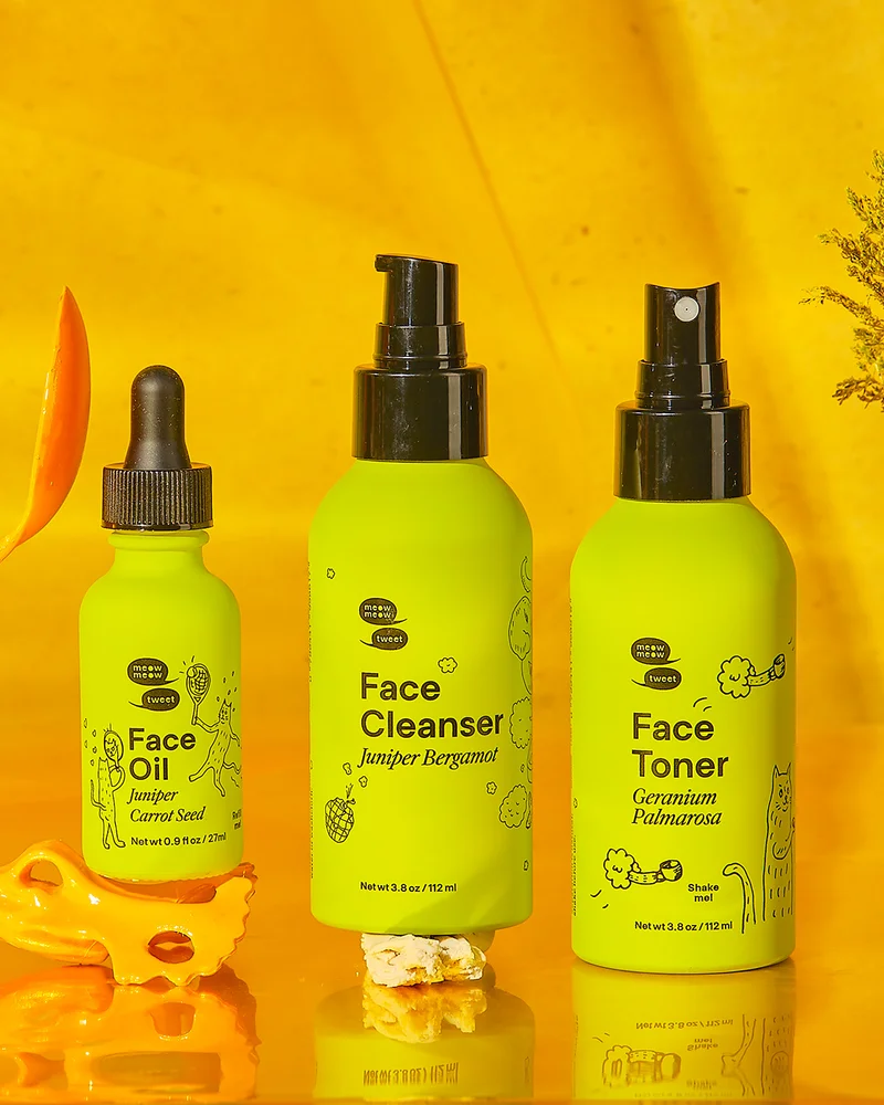 Three green bottles sit against a gold background