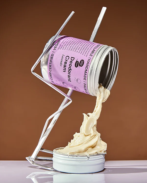 A purple-labeled bulk container has a swirl of cream falling into a waiting empty tin below