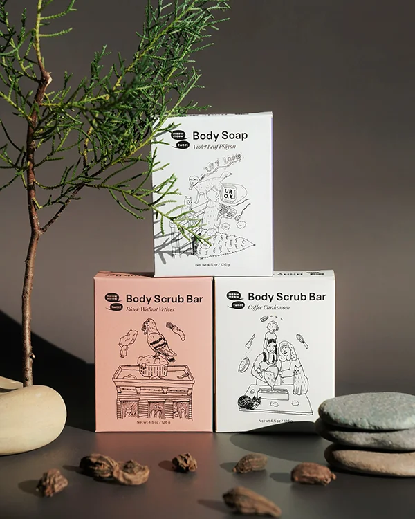 Three soaps are stacked with small tree-like branches and stones
