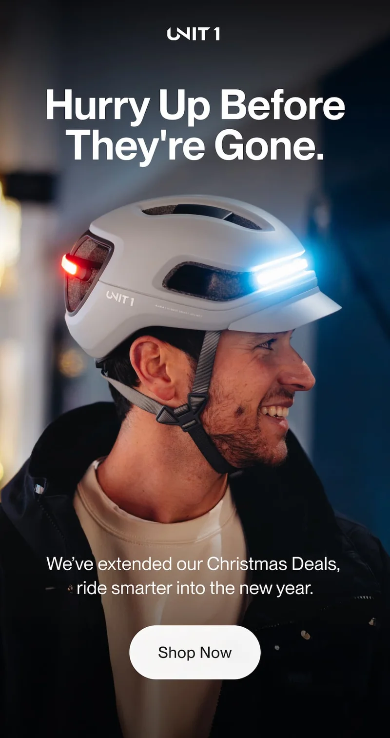 Man wearing a UNIT 1 smart bike helmet with front white light and rear red light illuminated, promoting extended Christmas deals