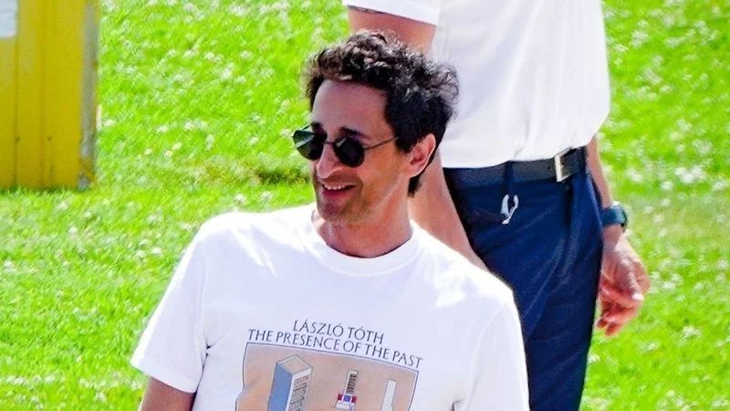 Image may contain: Adrien Brody, Clothing, T-Shirt, Accessories, Sunglasses, Adult, Person, Bag, Handbag, Glasses, and Belt