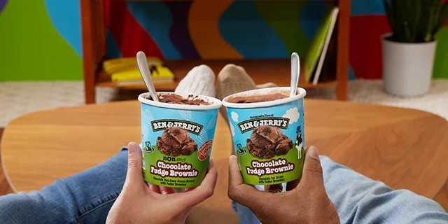 Hands holding pints of Ben & Jerry's ice cream