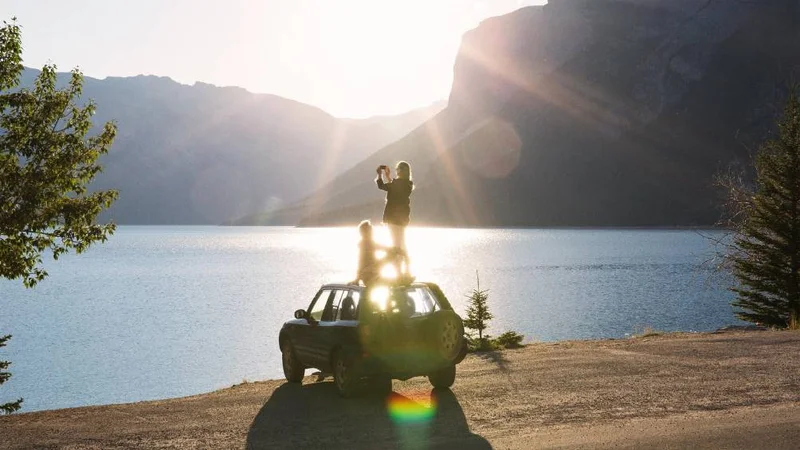 Image description: A woman takes a picture from a car roof in Canada.