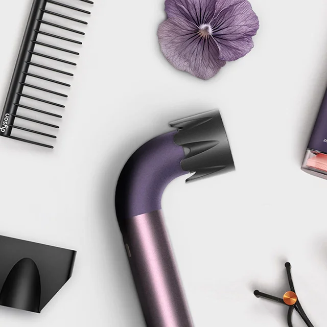 The Dyson Supersonic r hair dryer surrounded by attachments and accessories