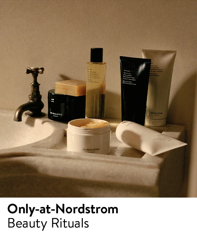 An assortment of bath and body care products from Jo Malone London on a counter next to a sink.