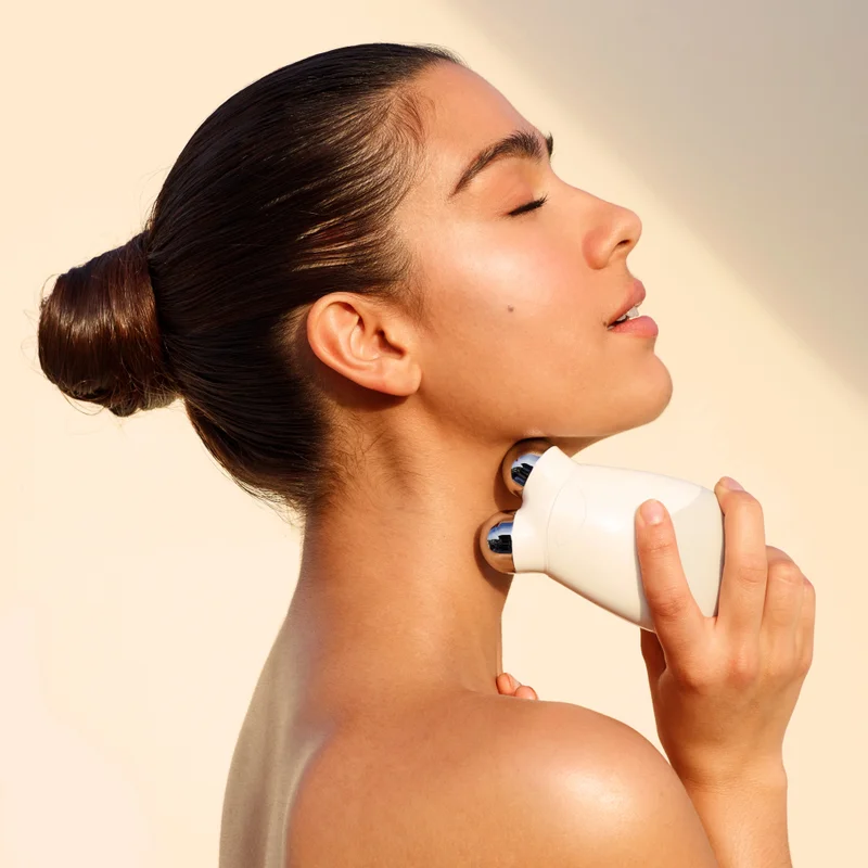 Woman targeting the neck area using the Trinity Facial Trainer Attachment