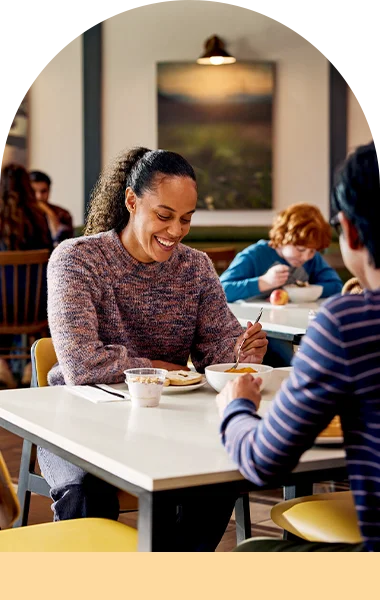 A woman is eating breakfast in the hotel cafeteria.