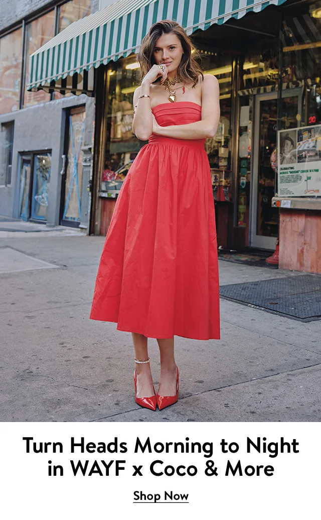 A woman wearing a red strapless dress and heels.