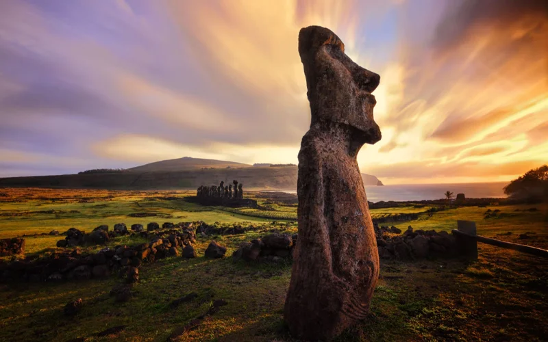 The sun sets behind Easter Island's monolithic statues, also known as moai.