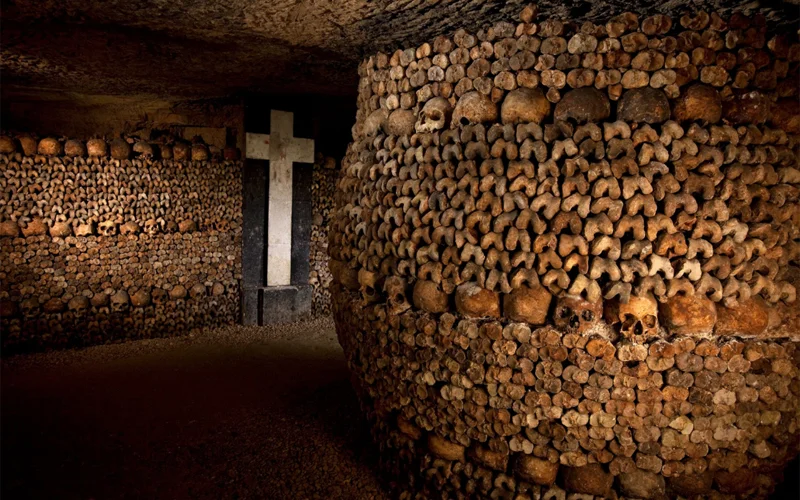 The ossuary in Les Catacombs de Paris is neatly stacked with the bones and skulls of millions of Parisians.