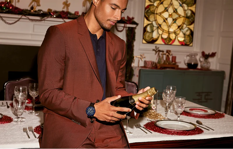 Person holding a champagne bottle and wearing