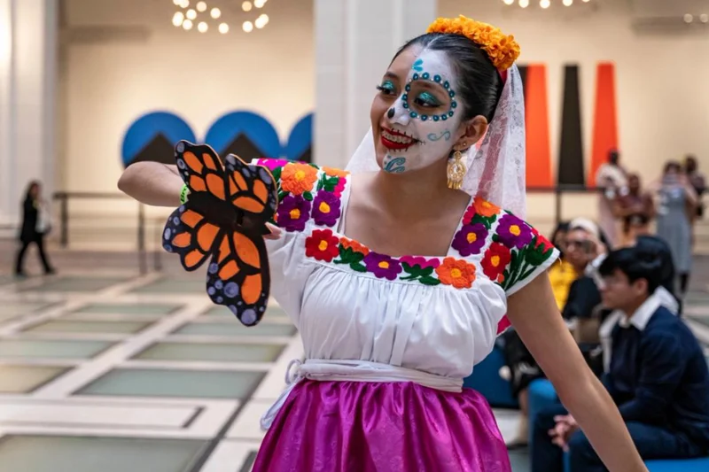 Person wearing Día de los Muertos makeup and a paper butterfly