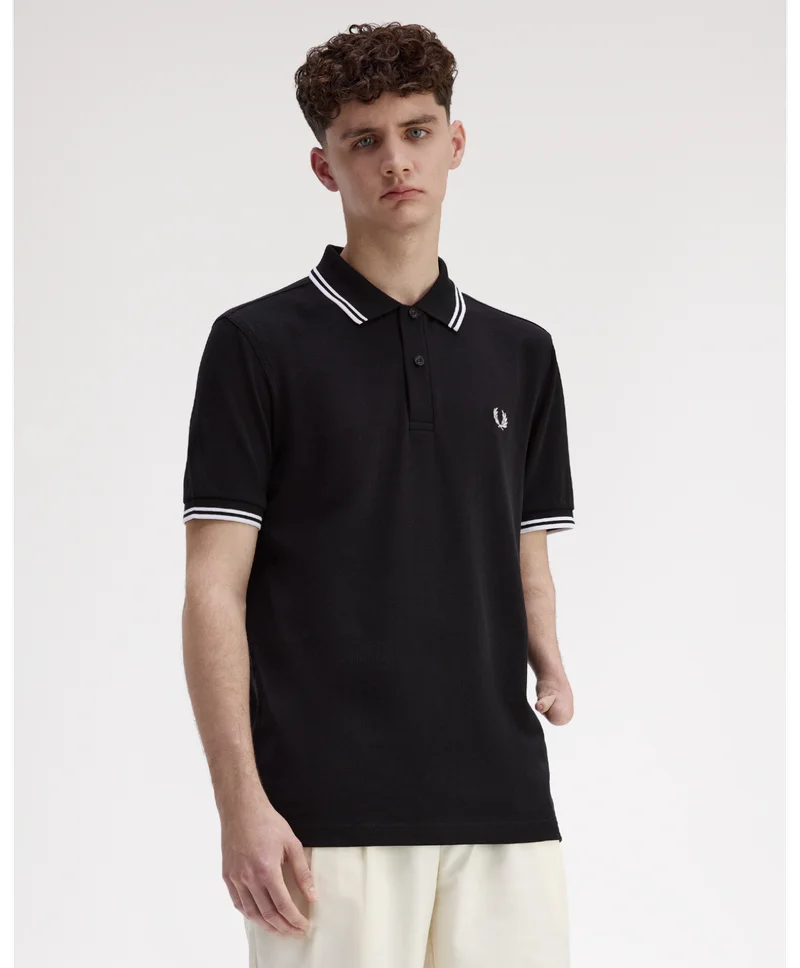 A male model with limb difference wears the Adaptive Fred Perry Shirt.