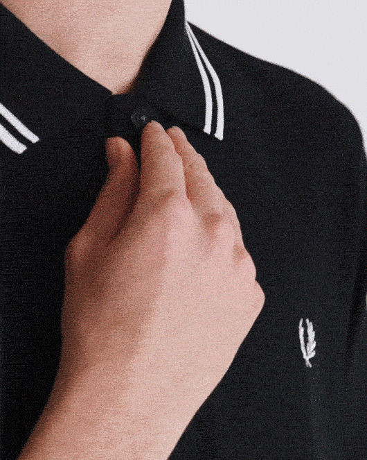 A male model with limb difference wears the Adaptive Fred Perry Shirt.