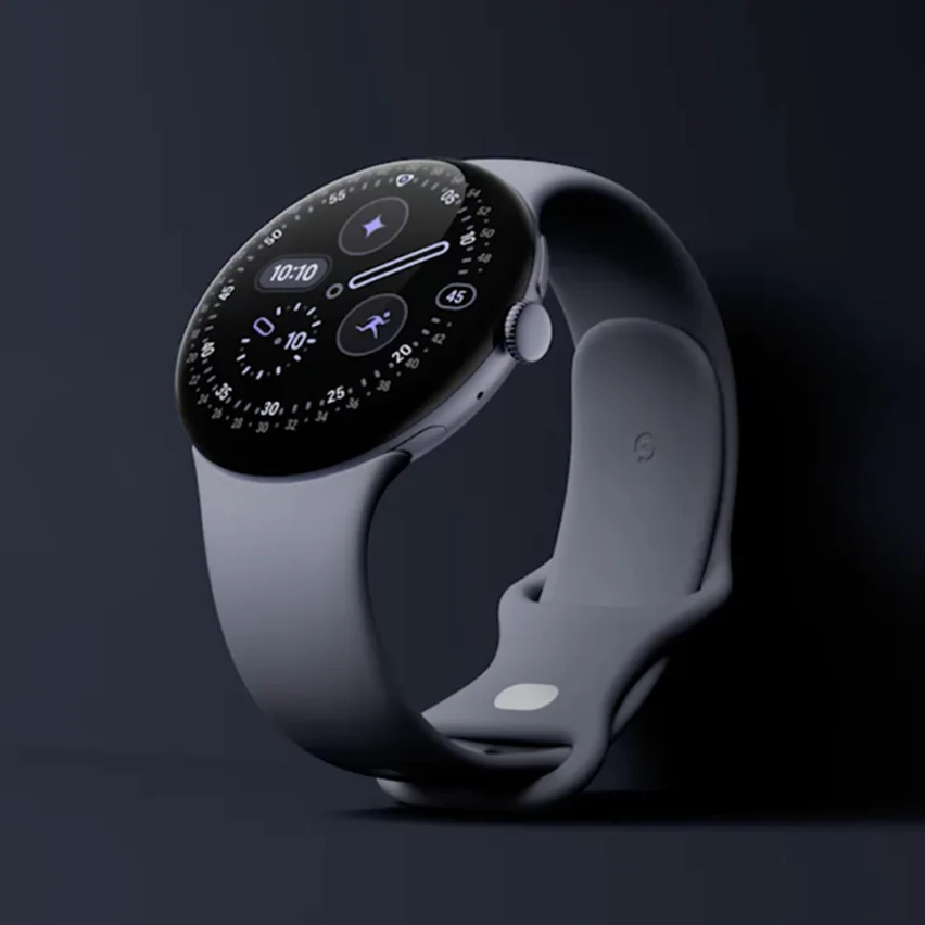 A low-light studio shot of a light blue Google Pixel Watch on a dark background. The circular watch face is lit up, displaying a digital time, activity trackers, and app icons.