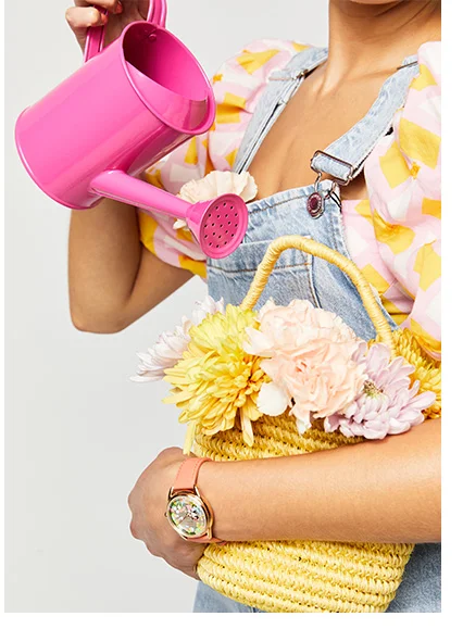 Person wearing Gardening Minnie and holding a basket of flowers and a watering can.