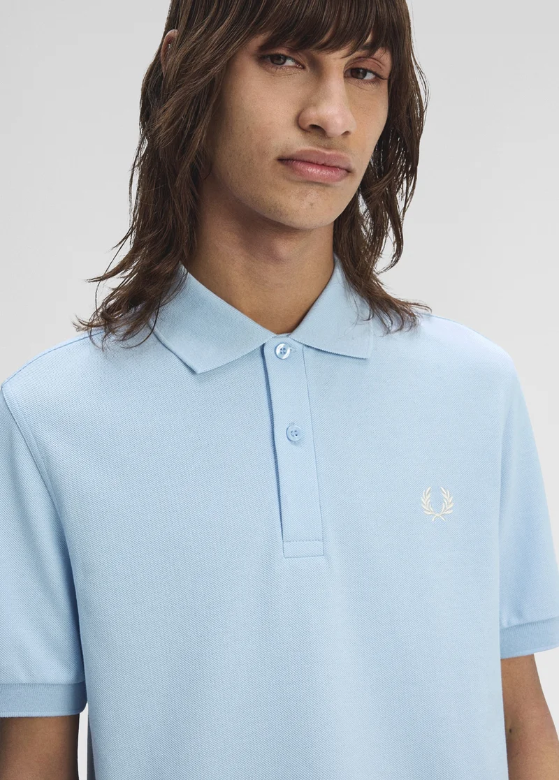 Male model wearing a one-colour Fred Perry polo in pale blue